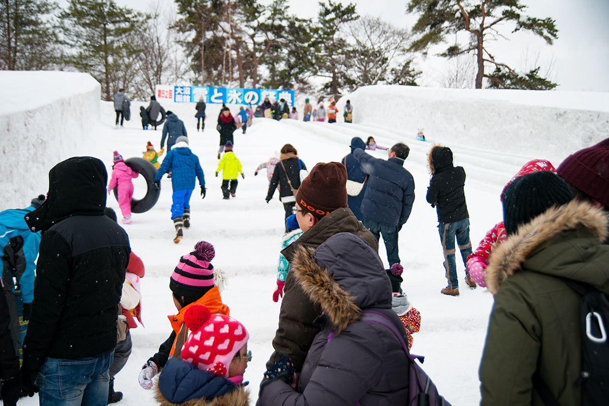 大沼函館「雪と氷の祭典」の滑り台で賑わう人たち